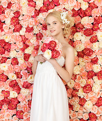 Image showing woman with bouquet and background full of roses