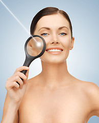 Image showing woman with magnifying glass and laser