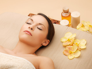 Image showing woman in spa salon lying on the massage desk