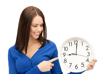 Image showing businesswoman pointing her finger at wall clock