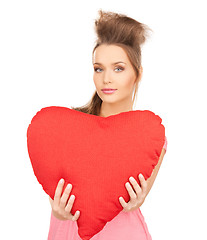 Image showing happy and smiling woman with heart-shaped pillow