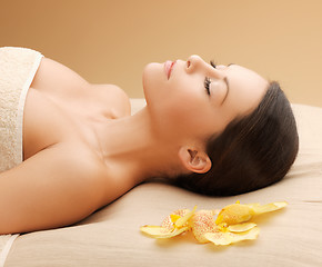 Image showing woman in spa salon lying on the massage desk