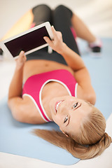 Image showing woman lying on the floor with tablet pc