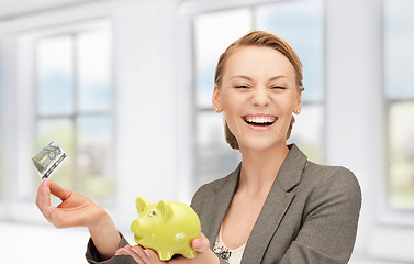 Image showing lovely woman with piggy bank and money