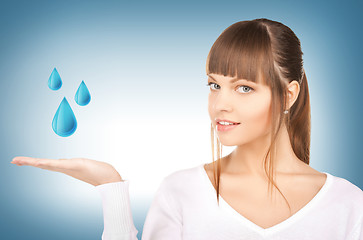 Image showing woman showing blue water drops