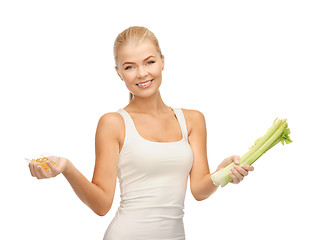 Image showing woman holding bunch of celery and vitamins