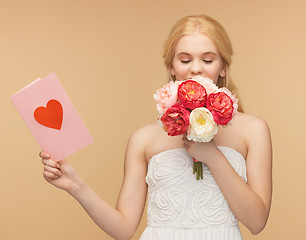 Image showing girl smelling flowers and holding postcard