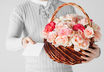 Image showing man holding basket full of flowers and postcard