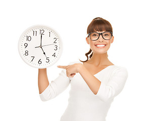 Image showing businesswoman pointing her finger at wall clock