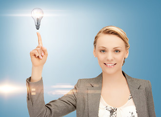 Image showing woman pointing her finger at light bulb