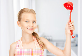 Image showing little housewife with red ladle at kitchen