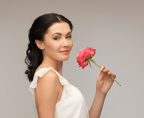 Image showing smiling woman smelling flower