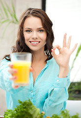 Image showing woman holding glass of juice and showing ok sign