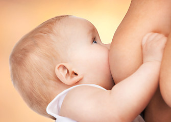 Image showing mother feeding adorable baby