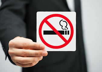 Image showing man in suit holding no smoking sign