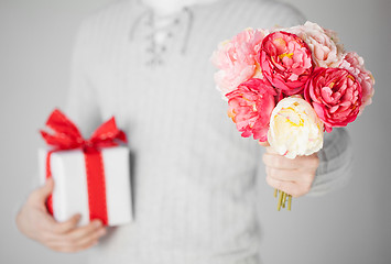 Image showing man holding bouquet of flowers and gift box