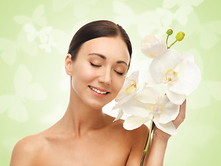 Image showing smiling woman with white orchid flower