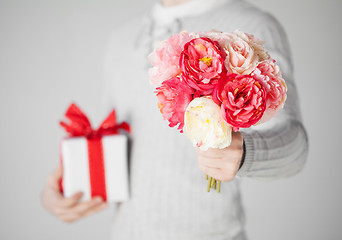 Image showing man holding bouquet of flowers and gift box