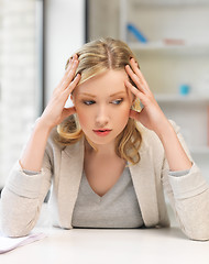 Image showing bored and tired woman behind the table