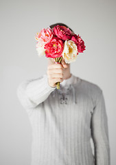 Image showing man covering his face with bouquet of flowers