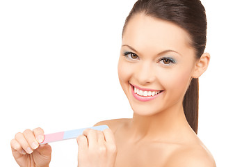 Image showing smiling young woman polishing her nails