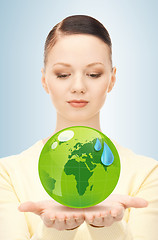 Image showing woman holding green globe in her hands