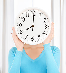 Image showing businesswoman with clock over her face