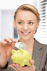 Image showing lovely woman with piggy bank and money