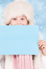 Image showing girl in winter hat with blank board