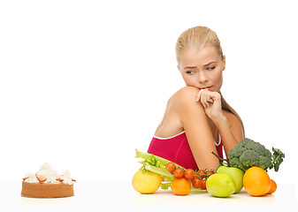 Image showing doubting woman with fruits and hamburger