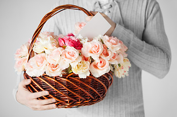 Image showing man holding basket full of flowers and postcard