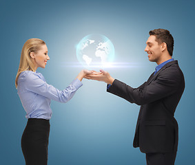 Image showing man and woman showing earth globe on the palms