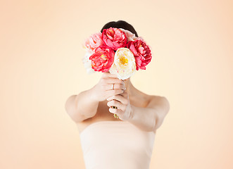 Image showing woman holding bouquet of flowers over her face