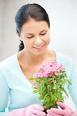 Image showing lovely housewife with flower in pot