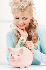 Image showing woman with piggy bank and cash money