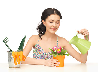 Image showing housewife with flower in pot and watering can