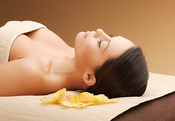 Image showing woman in spa salon lying on the massage desk