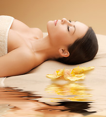 Image showing woman in spa salon lying on the massage desk