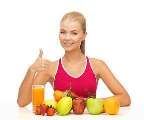 Image showing woman with juice and fruits showing thumbs up