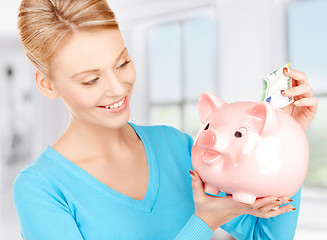 Image showing lovely woman with piggy bank and money