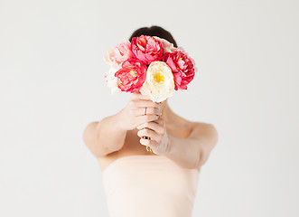 Image showing woman holding bouquet of flowers over her face