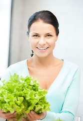 Image showing woman in the kitchen with green salad leaves