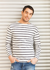 Image showing handsome man in casual clothes leaning to wall