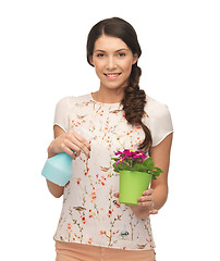 Image showing woman holding pot with flower and spray bottle