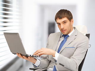 Image showing young businessman sitting in chair with laptop