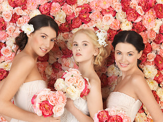 Image showing three women with background full of roses