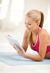 Image showing woman lying on the floor with tablet pc