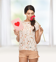 Image showing young woman holding flower and  postcard