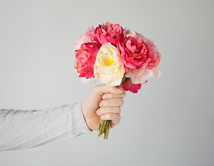 Image showing man's hand giving bouquet of flowers