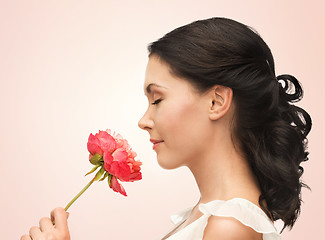 Image showing smiling woman smelling flower